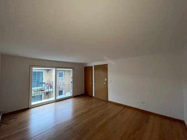 an empty room with wooden floor and window