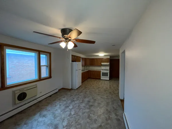 a view of an empty room with a ceiling fan and window