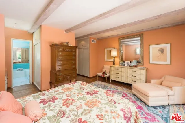 a bedroom with a bed and dresser with mirror