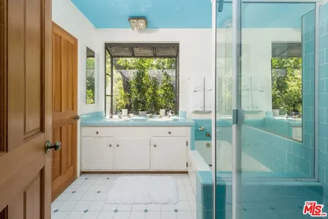 a bathroom with a window sink and cabinets