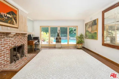 a living room with fireplace furniture and a large window