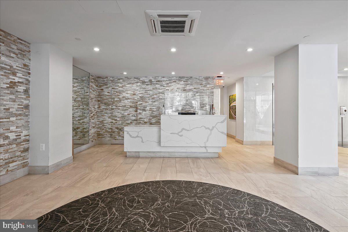 1301 North Courthouse Road, Unit 1202 Arlington, VA 22201 - Photo 14 of 17 a view of a hallway with a couch and chandelier