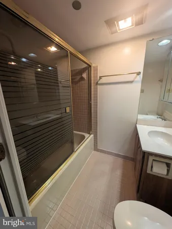 a bathroom with a sink a toilet a mirror and shower