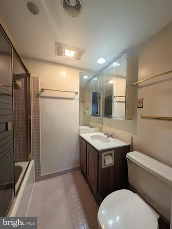 a bathroom with a granite countertop sink mirror vanity and toilet