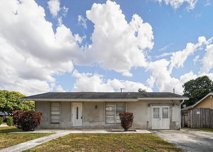 22164 Southwest 65th Terrace Boca Raton, FL 33428 - Photo 1 of 20 a front view of a house with garden