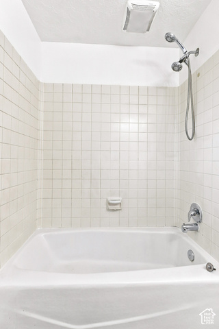 224 Canal Bank Road Garland, UT 84312 - Photo 16 of 21 Bathtub with white tile surround, chrome fixtures, and a ceiling-mounted ventilation unit