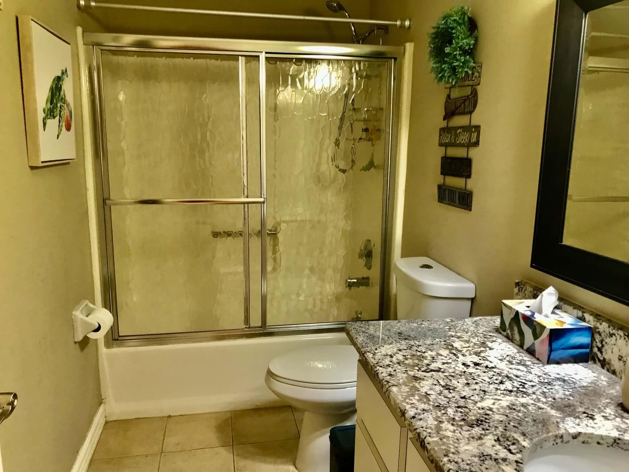 1115 Elm Street Okeechobee, FL 34974 - Photo 23 of 37 a bathroom with a granite countertop sink toilet and shower