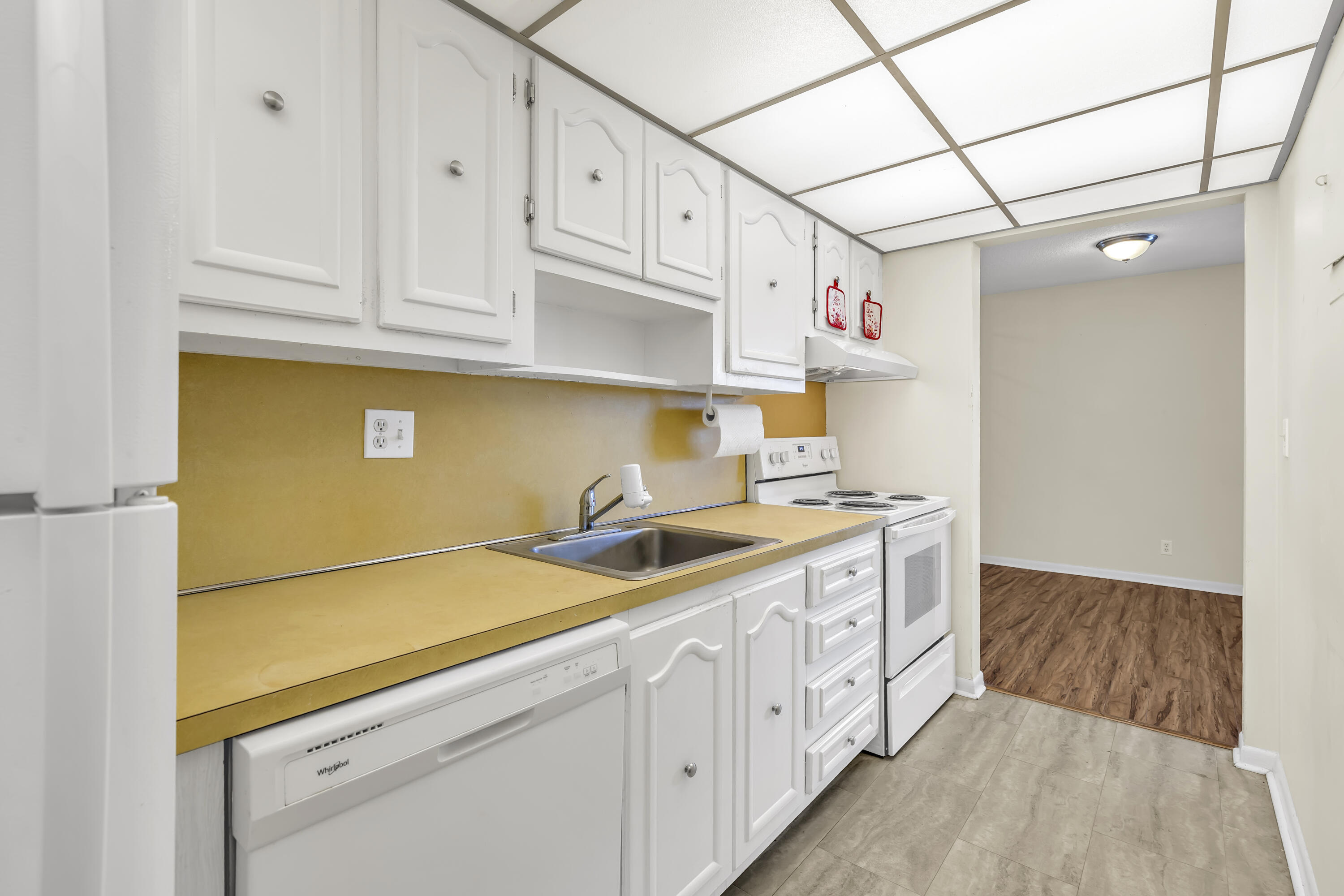 298 Southwest 6th Street, Unit 204 Boca Raton, FL 33432 - Photo 12 of 22 a kitchen with granite countertop a white cabinets and white appliances