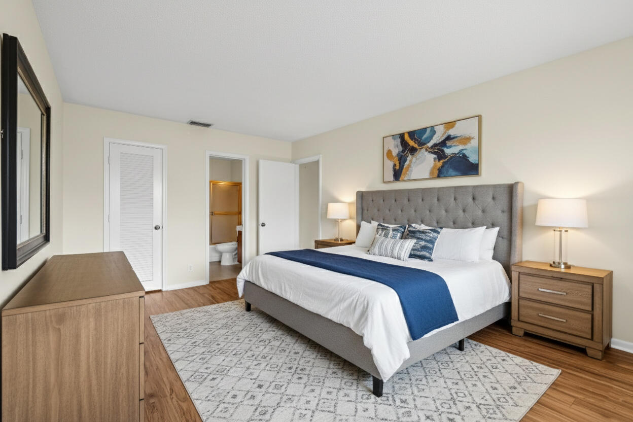 298 Southwest 6th Street, Unit 204 Boca Raton, FL 33432 - Photo 15 of 22 a bedroom with a bed and wooden floor