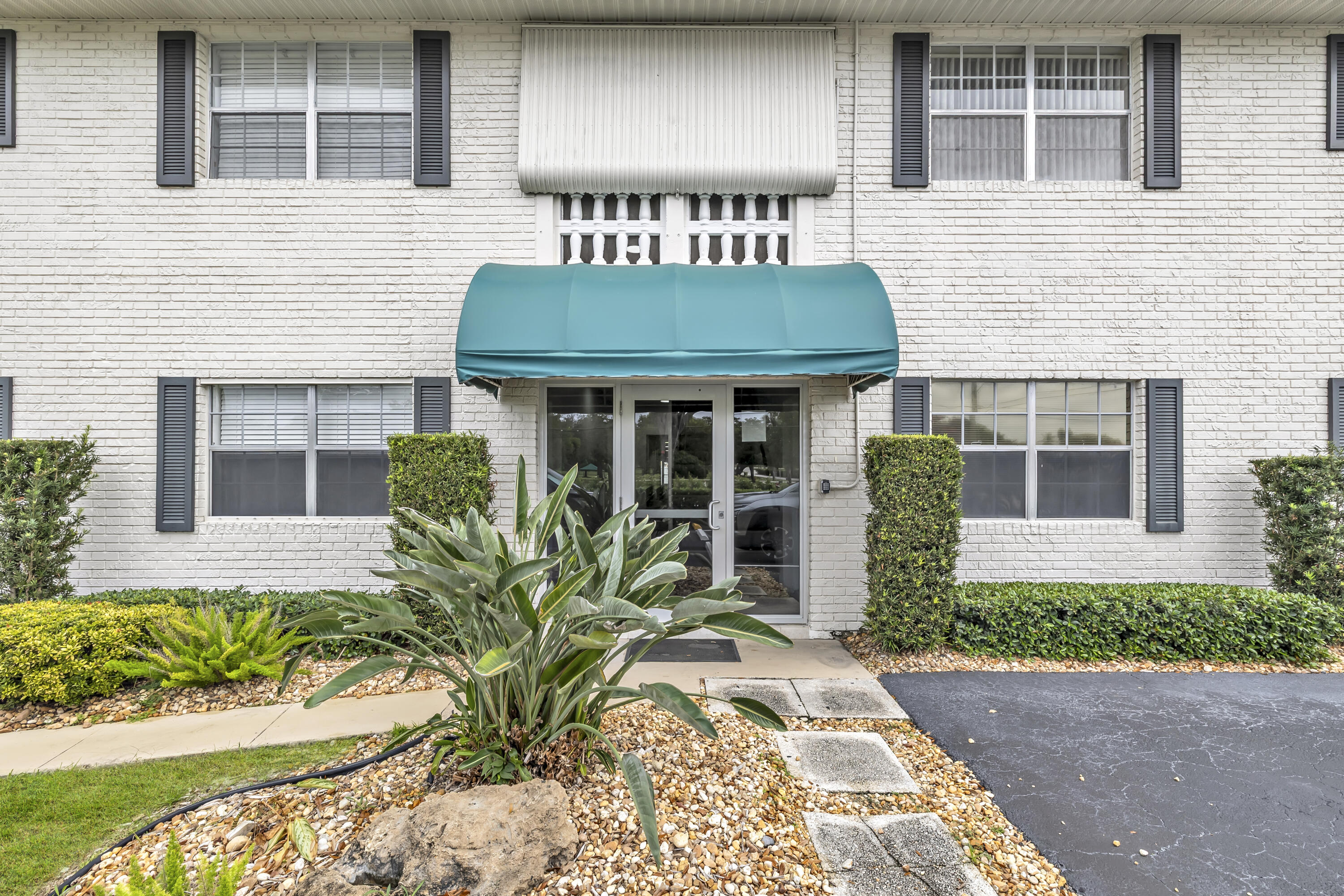 298 Southwest 6th Street, Unit 204 Boca Raton, FL 33432 - Photo 2 of 22 a view of a house with a large window and flower plants