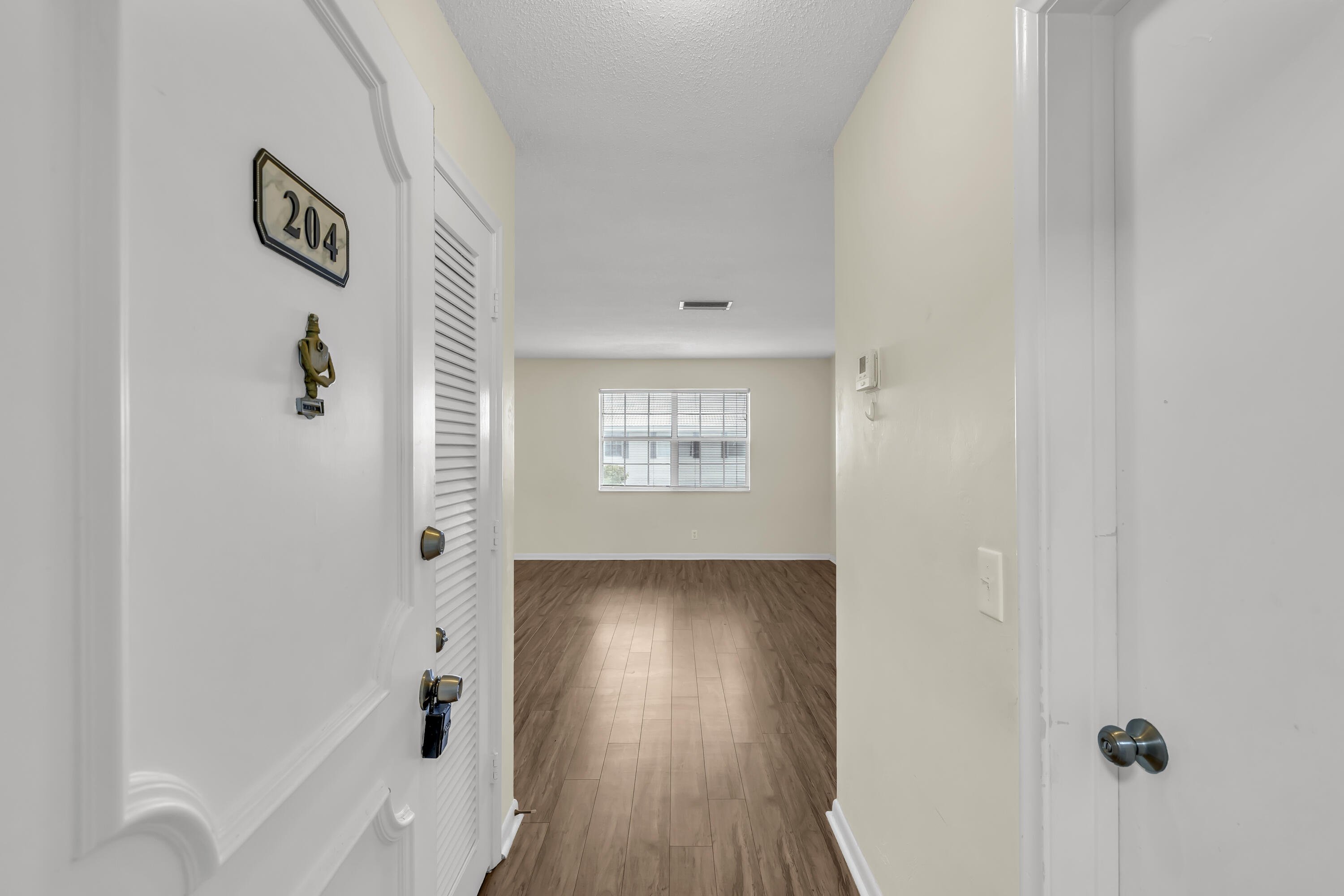 298 Southwest 6th Street, Unit 204 Boca Raton, FL 33432 - Photo 4 of 22 a view of a hallway with wooden floor