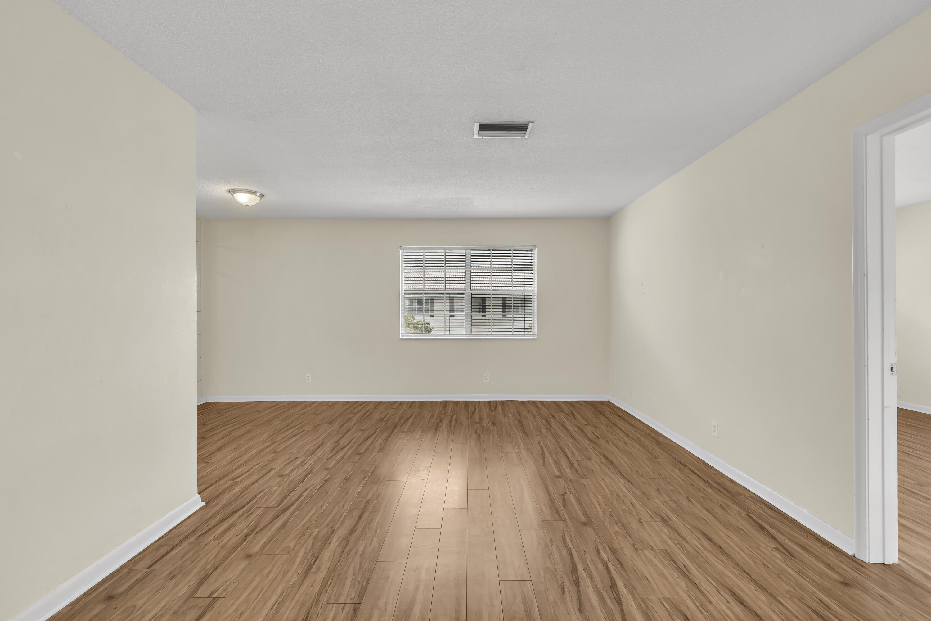 298 Southwest 6th Street, Unit 204 Boca Raton, FL 33432 - Photo 5 of 22 an empty room with wooden floor and windows