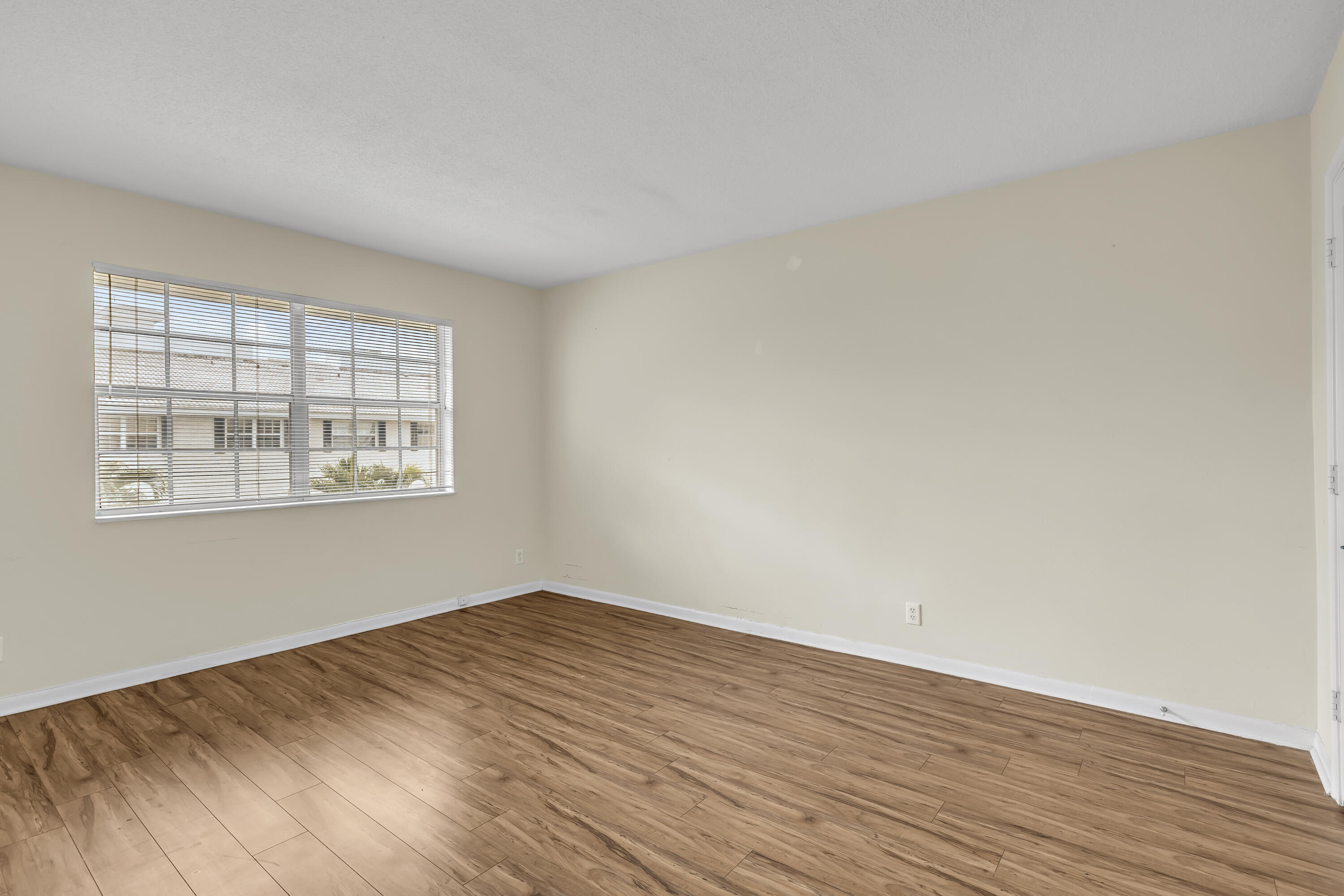 298 Southwest 6th Street, Unit 204 Boca Raton, FL 33432 - Photo 7 of 22 an empty room with wooden floor and windows