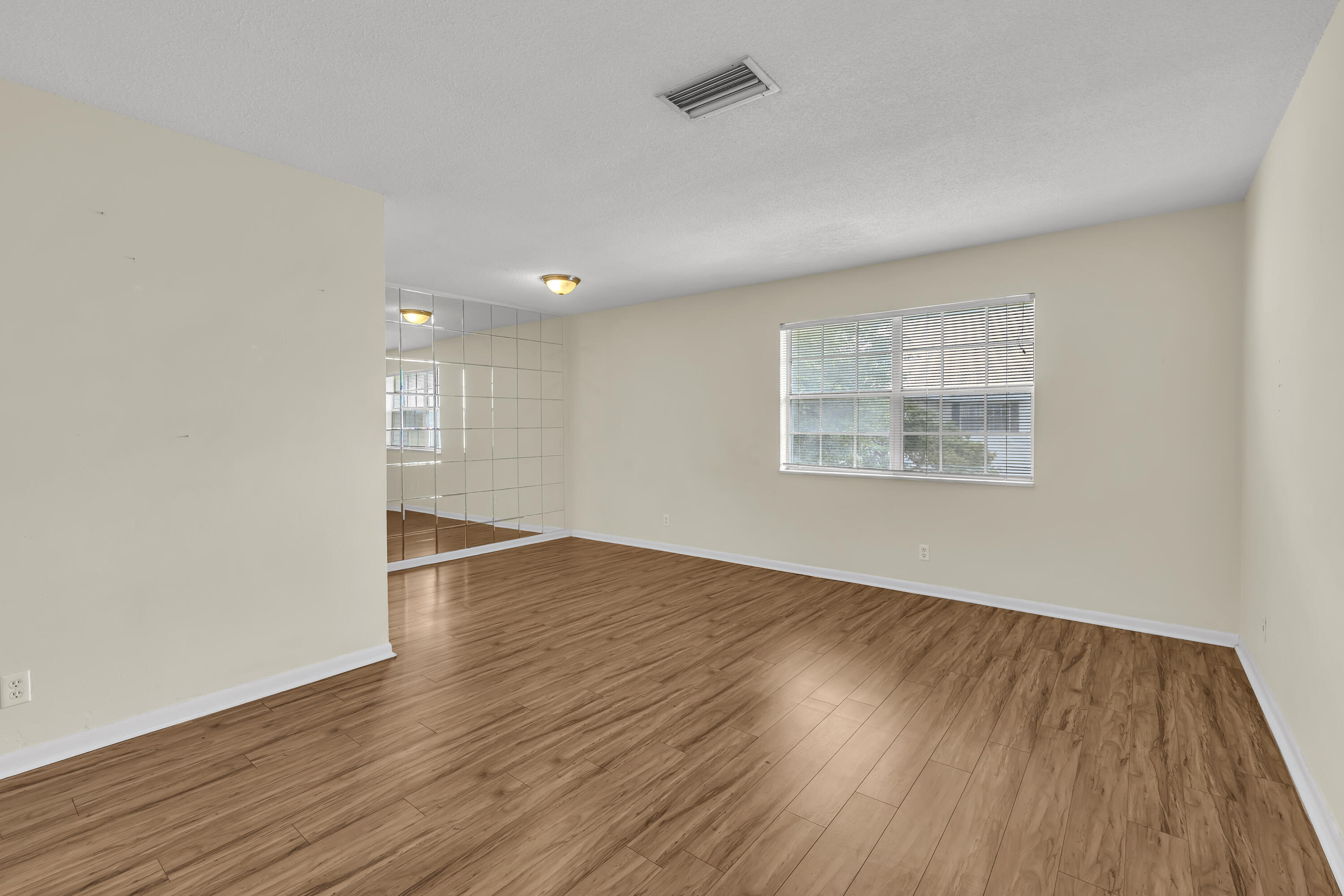 298 Southwest 6th Street, Unit 204 Boca Raton, FL 33432 - Photo 8 of 22 an empty room with wooden floor and windows