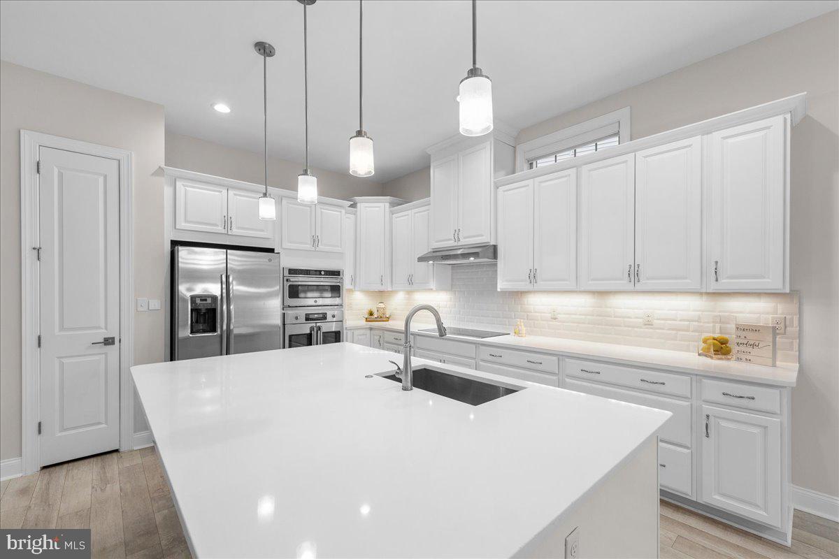 13712 Long Ridge Drive Gainesville, VA 20155 - Photo 11 of 62 a kitchen with kitchen island a sink stainless steel appliances and cabinets