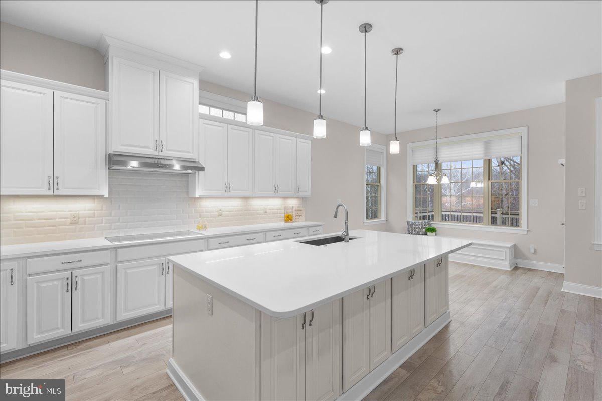 13712 Long Ridge Drive Gainesville, VA 20155 - Photo 12 of 62 a kitchen with a stove a sink a center island and wooden floor
