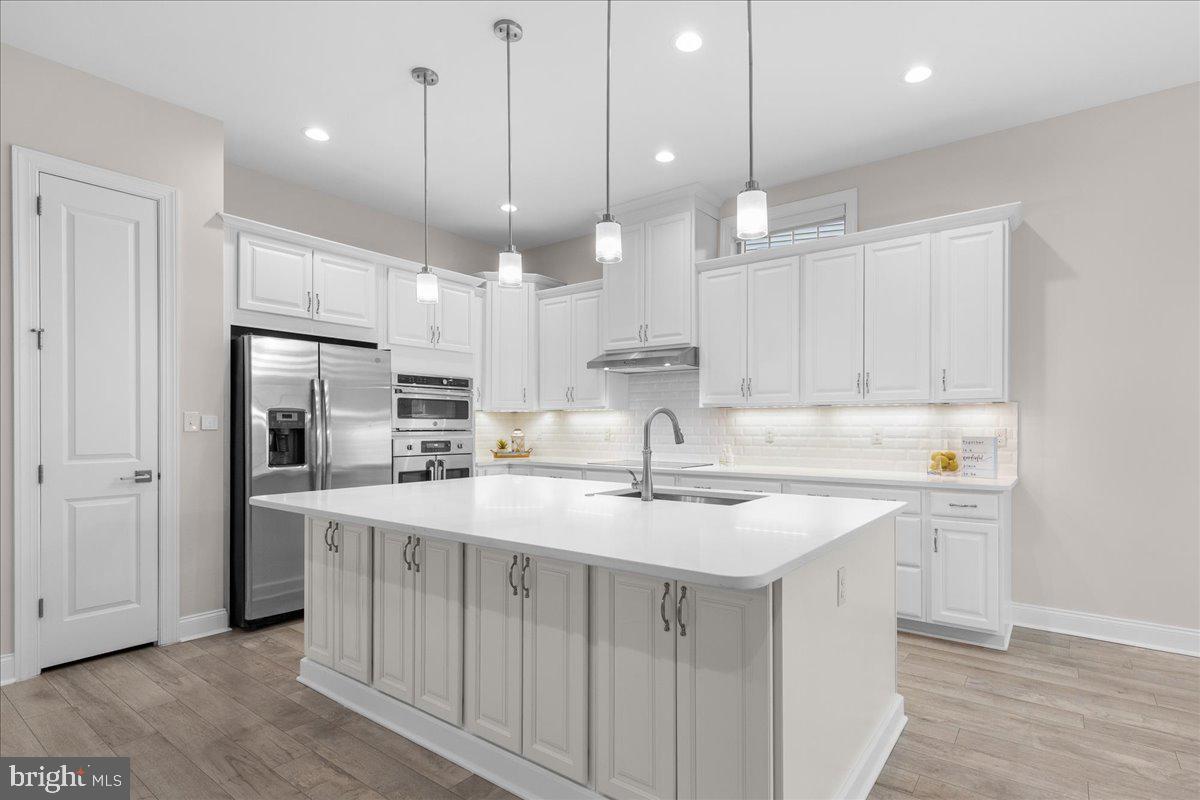 13712 Long Ridge Drive Gainesville, VA 20155 - Photo 9 of 62 a kitchen with kitchen island a sink stainless steel appliances and cabinets