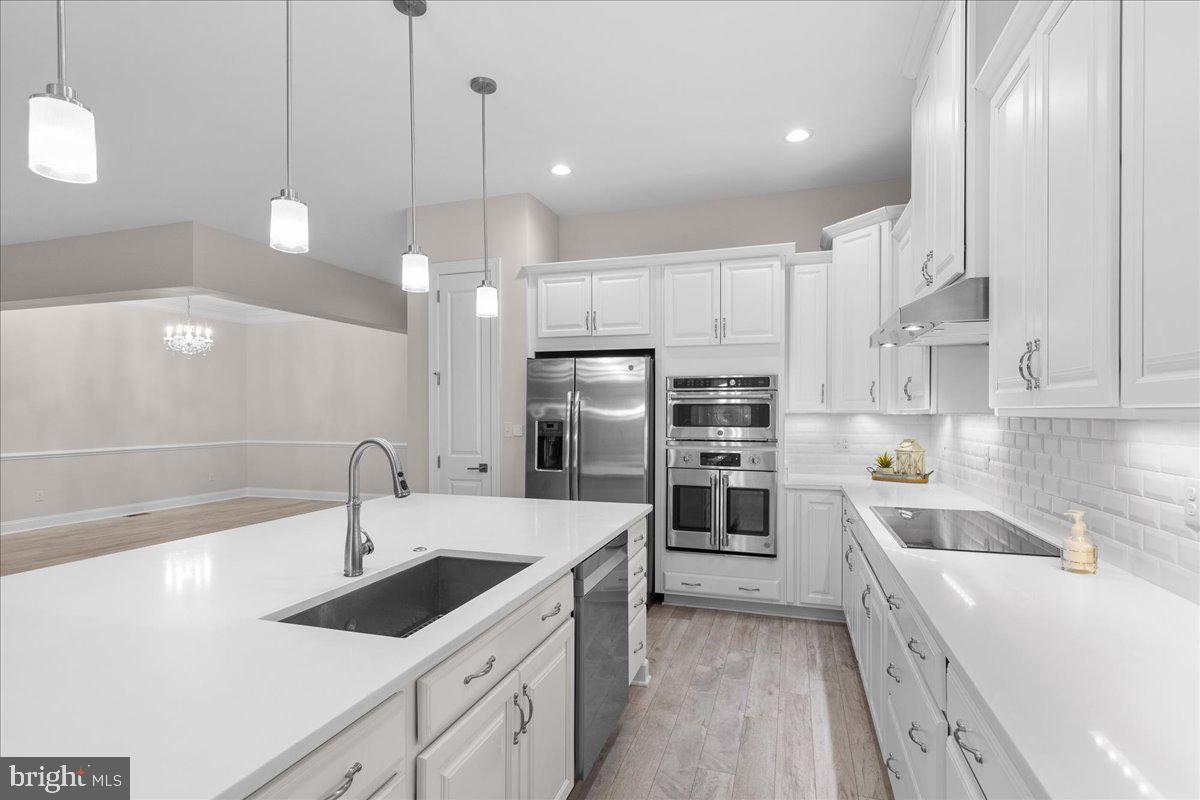 13712 Long Ridge Drive Gainesville, VA 20155 - Photo 10 of 62 a kitchen with kitchen island a sink stainless steel appliances and cabinets