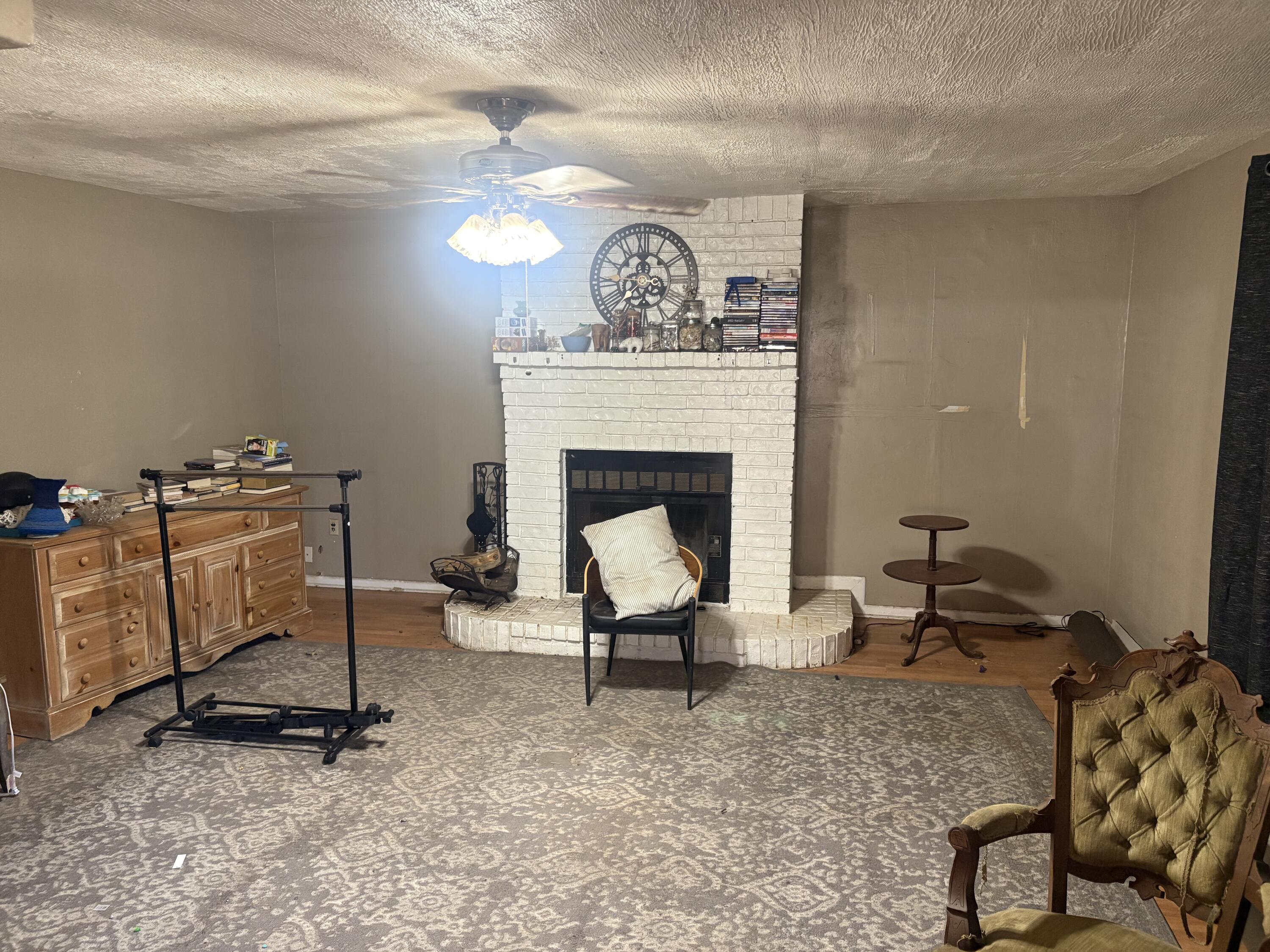 2009 46th Street Lubbock, TX 79412 - Photo 7 of 41 a living room with furniture a fireplace and a chandelier