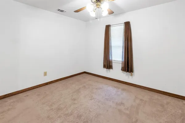 an empty room with a chandelier fan