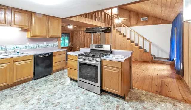 a kitchen with stainless steel appliances granite countertop a stove a sink and a microwave