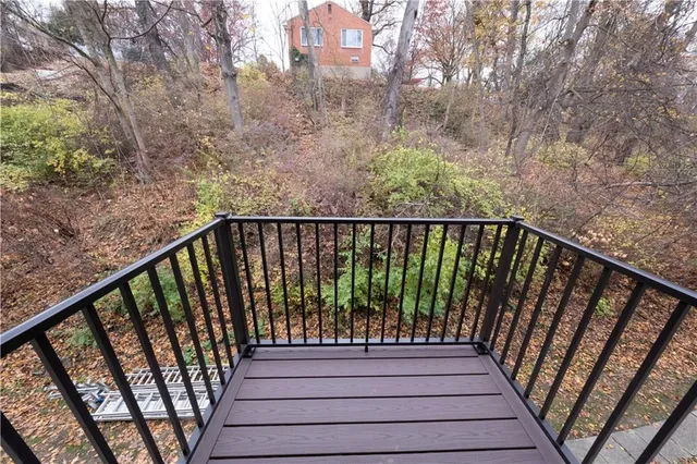a view of balcony with wooden floor and fence