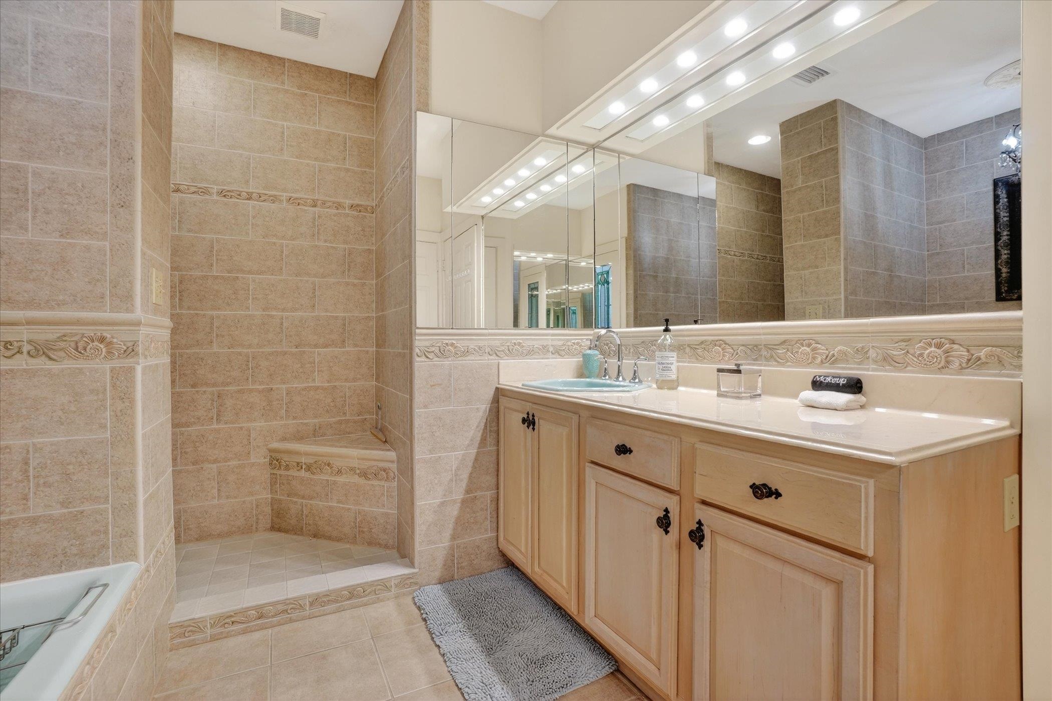 16 May Street St. Augustine, FL 32084 - Photo 55 of 85 Bathroom featuring tile walls, vanity, a walk in shower, and light tile patterned flooring
