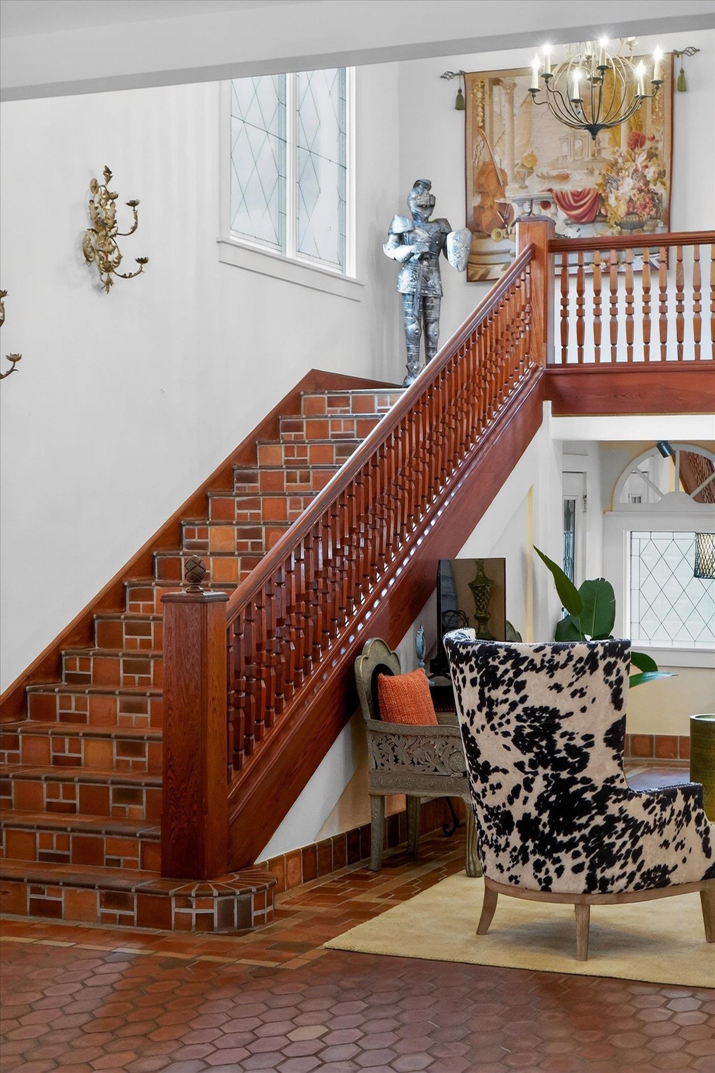 16 May Street St. Augustine, FL 32084 - Photo 61 of 85 Stairway with healthy amount of natural light, a high ceiling, and a chandelier