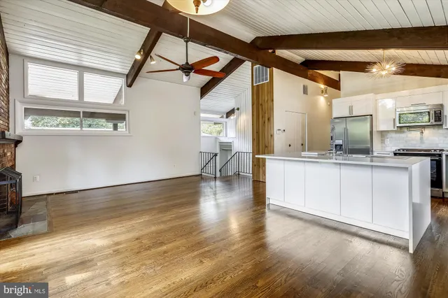 a hallway with white cabinets and wooden floor