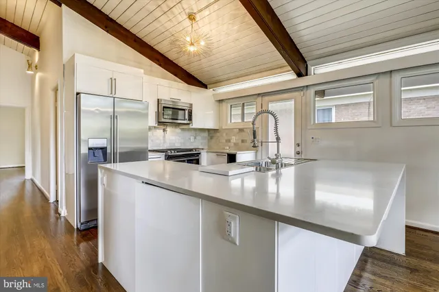 a kitchen with stainless steel appliances granite countertop a sink a stove and a refrigerator