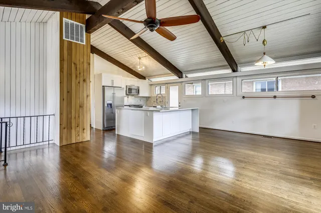 a view of a kitchen with wooden floor and electronic appliances