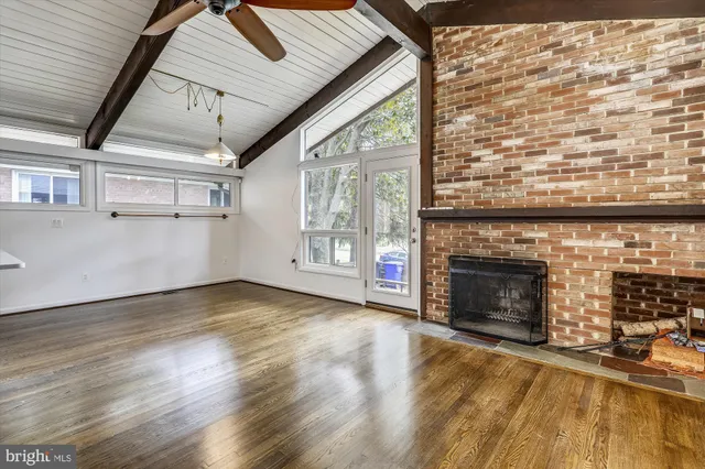 a view of empty room with wooden floor and fireplace