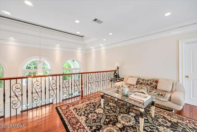 a kitchen with stainless steel appliances granite countertop a stove a refrigerator a kitchen island a dining table and chairs with wooden floor