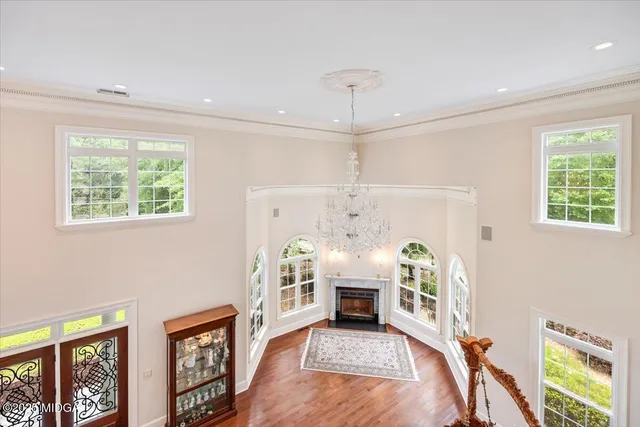 a living room with furniture large window and wooden floor