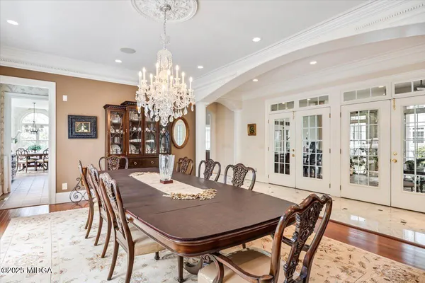 a dining room with furniture a chandelier and wooden floor