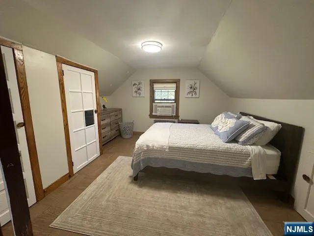 a spacious bedroom with a bed and a refrigerator