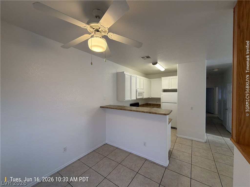 4730 East Craig Road, Unit 1124 Las Vegas, NV 89115 - Photo 7 of 22 A well-lit kitchen with classic white cabinetry and practical tile flooring.