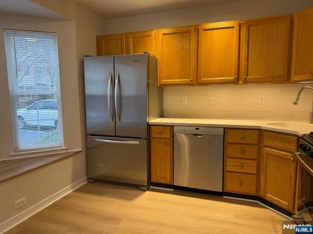 a kitchen with stainless steel appliances granite countertop a refrigerator and a sink