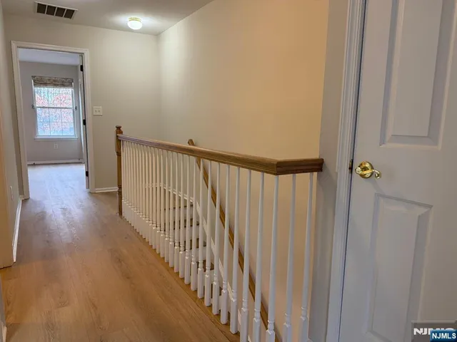 a view of a hallway with wooden floor and entryway