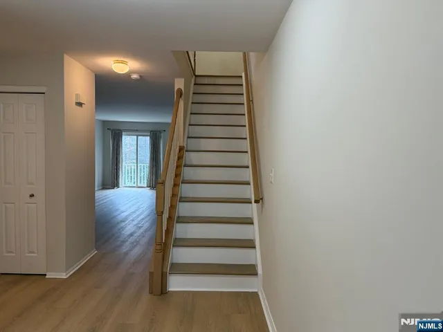 a view of a hallway with wooden floor and entryway