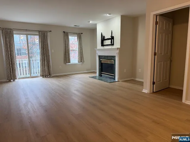 an empty room with windows and a fireplace