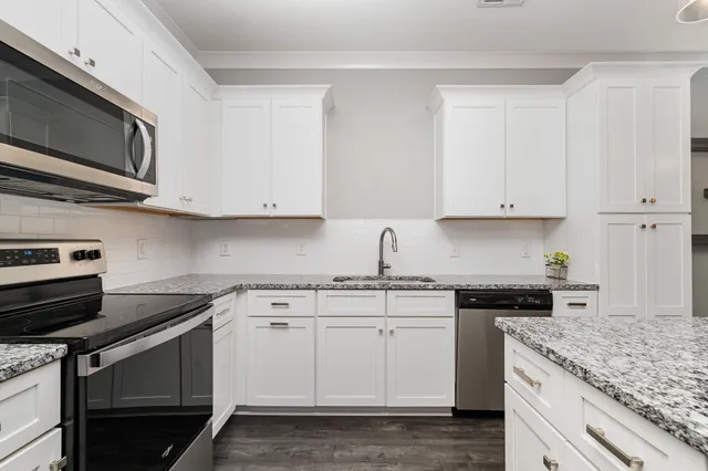 a kitchen with stainless steel appliances granite countertop a stove a microwave and a refrigerator