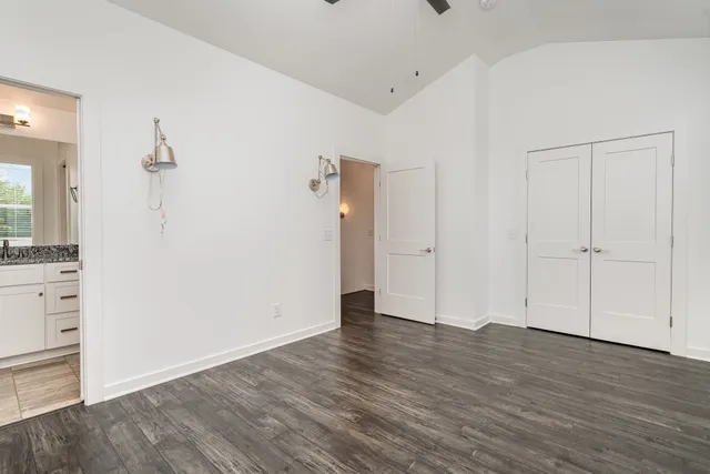 a bathroom with a granite countertop toilet a sink and a mirror