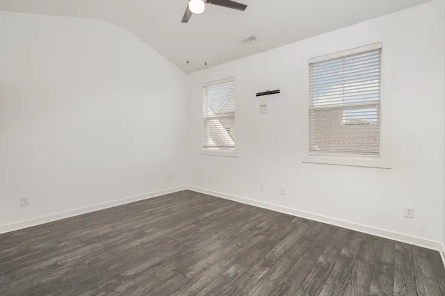 a view of an empty room with wooden floor and closet