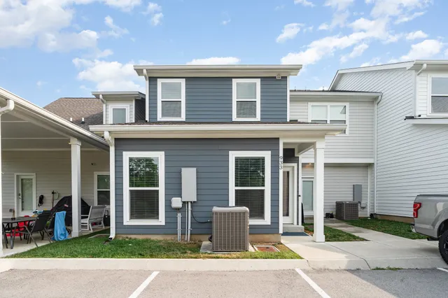 a view of a house with a patio and a yard
