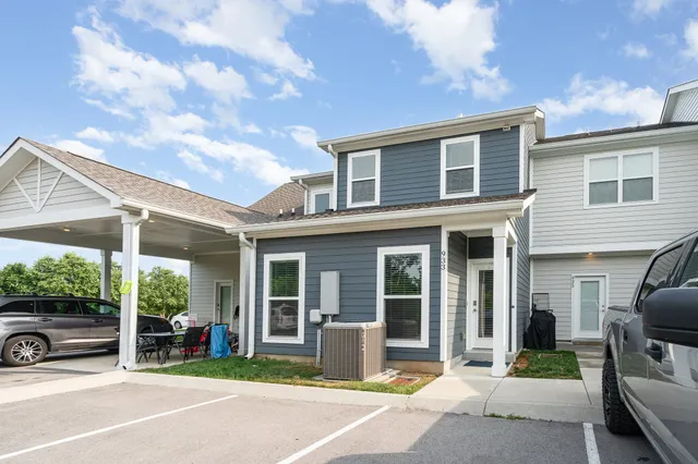a view of swimming pool with lawn chairs and plants