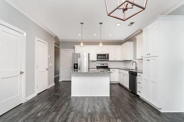 a kitchen with stainless steel appliances granite countertop a sink stove and microwave
