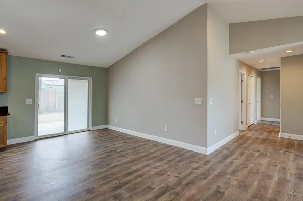 a view of an empty room with wooden floor