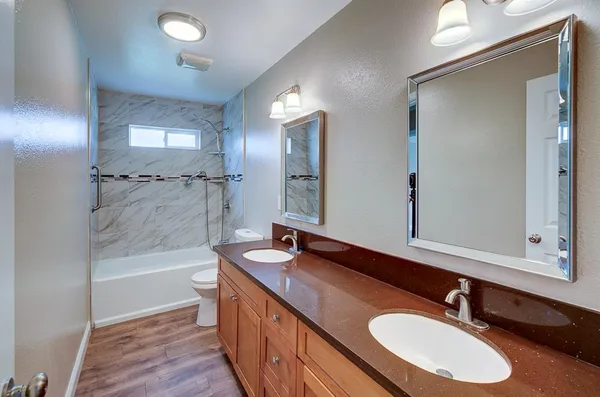 a bathroom with a sink double vanity granite tub and shower