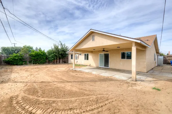 a view of a house with a backyard and trees
